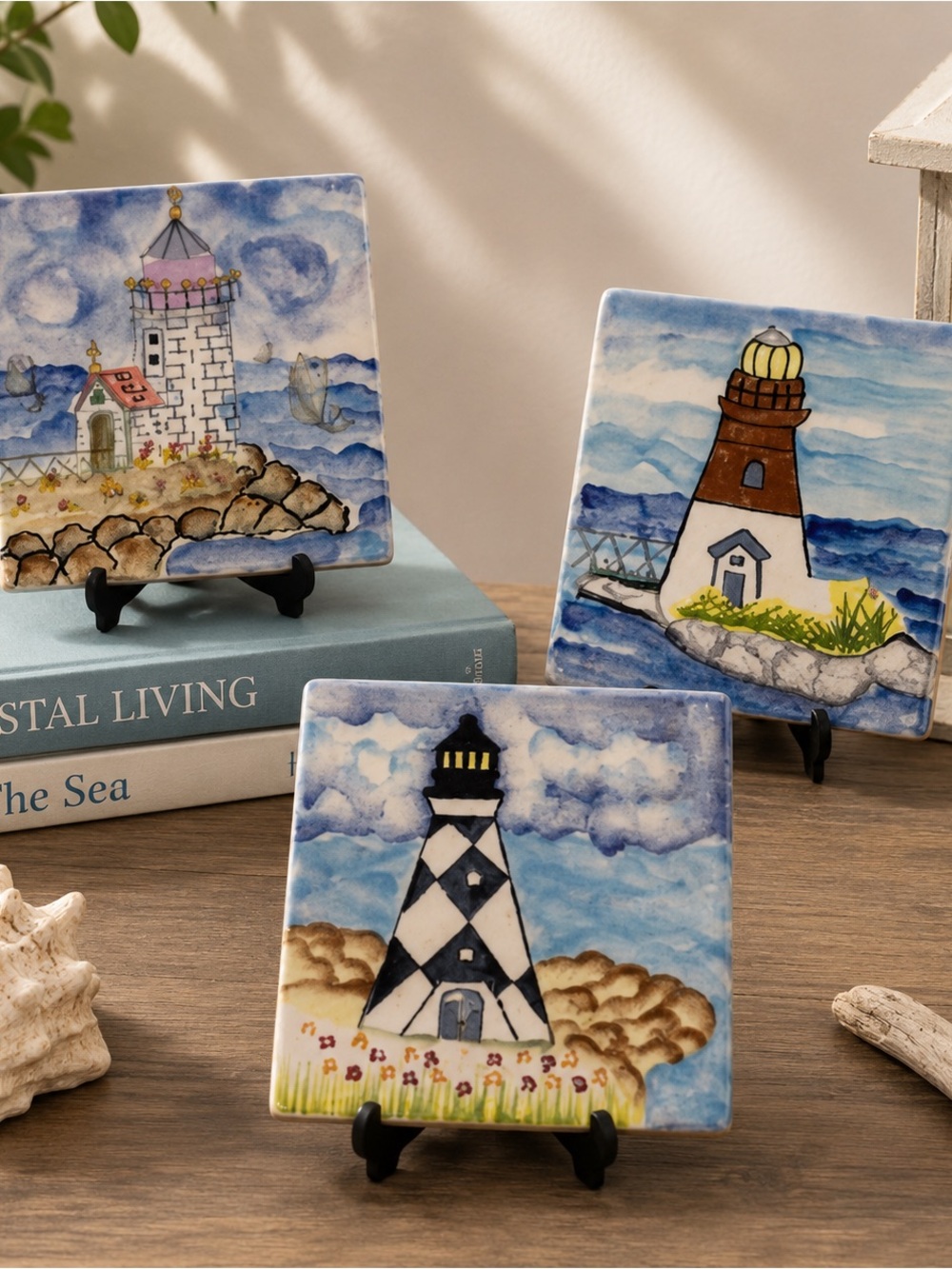 Lot of three decorative ceramic tiles featuring lighthouse designs